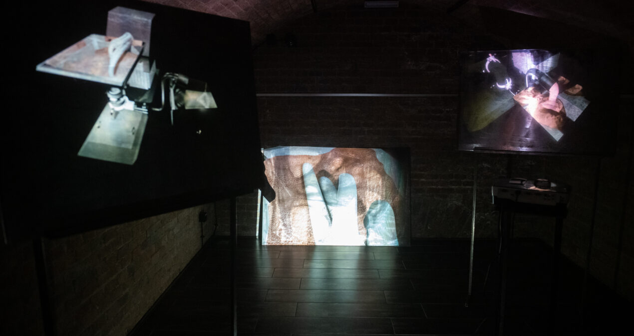 Jedna z prac prezentowanych na wystawie. Na trzech ekranach wyświetlany jest film przedstawiający tajemniczą maszynę.