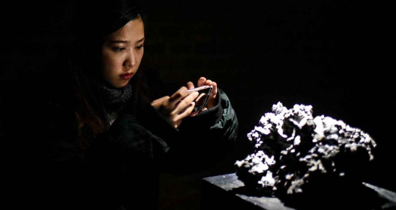 Dziewczyna robi komórką zdjęcie rzeźby przypominającej fragment skały