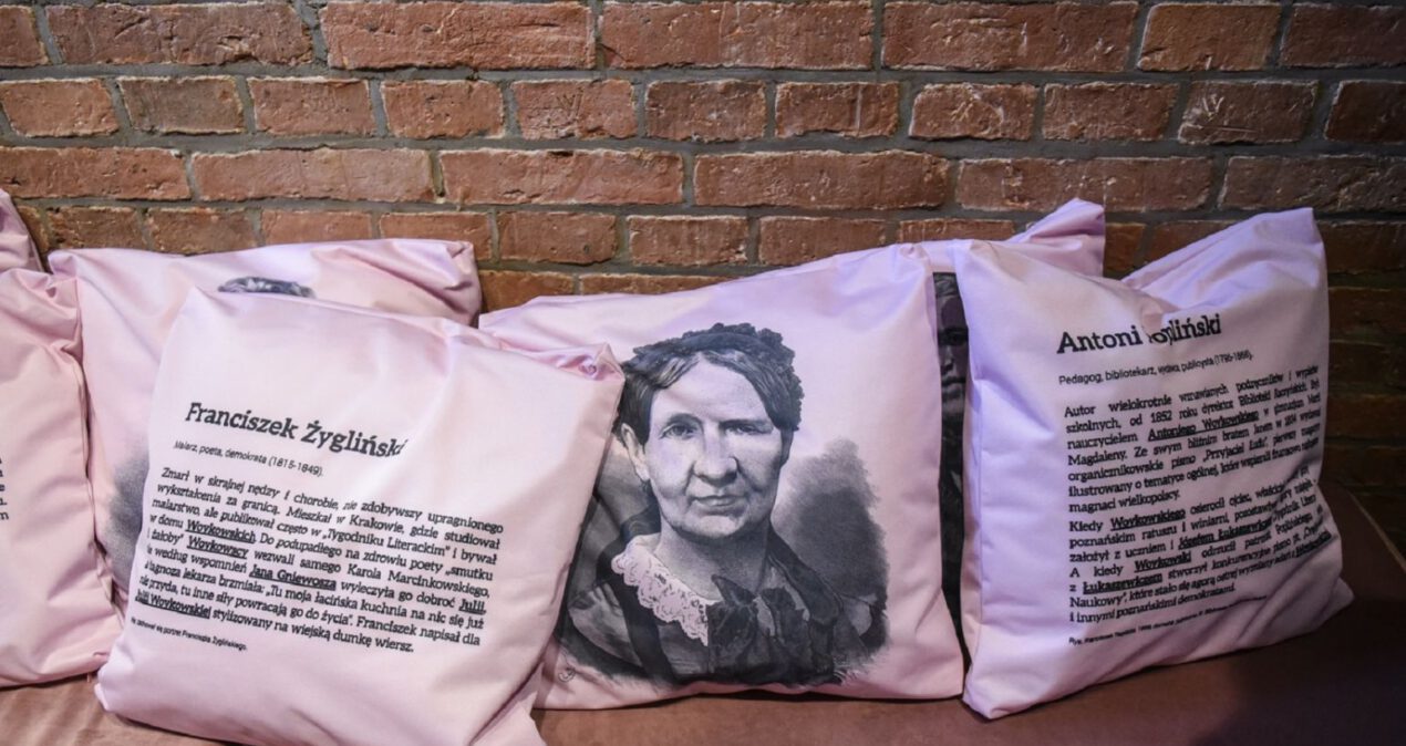 Różowe poduszki z wizerunkami w biografiami osób z czasów Julii Woykowskiej